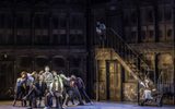 Nick Piazza (Joe Boyle)  singing surrounded by ensemble while Serena sits on the stairs. Credit: Johan Persson