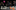 Dancers in motion, wearing black attire, practice energetic moves on stage. Colourful graphics, stars, and 